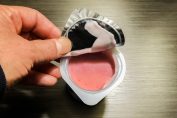 Ouverture de la fraîcheur du yogourt aux fraises et d’un contenant en plastique à service unique