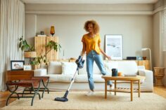 Une femme passe un aspirateur laveur sur un tapis.
