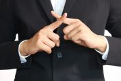 Un homme en costume fait « non » avec ses mains
